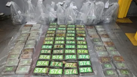 Numerous green parcels of cocaine, with clear plastic bags