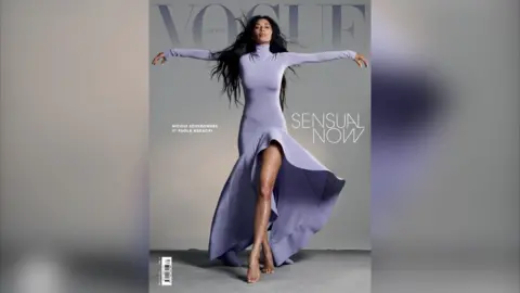 Vogue Greece/Paola Kudacki The singer Nicole Scherzinger posing on the front cover of the magazine Vogue Greece. She is wearing a lilac dress, has her arms outstretched and her dark hair is cascading over her shoulder