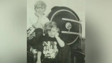 Steve Johnson A black and white image of a news paper of a young boy and a young girl posing in front of a miniature train.