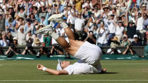 Arthur Fery falls on his back after beating Flavio Cobolli at Wimbledon