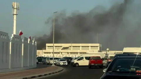 Reuters A photograph of smoke in the air behind a white building. 