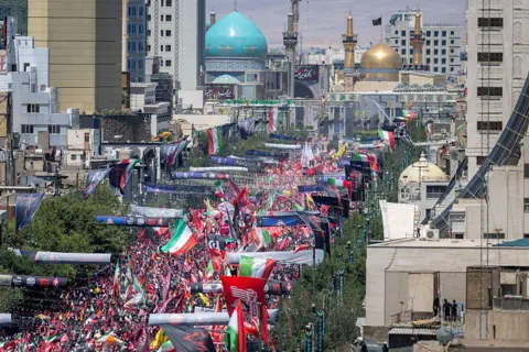 Getty Images Thousands of mourners gather on a boulevard in Mashhad, northeastern Iran, ahead of the burial of Iran's late Supreme Leader Ayatollah Ali Khamenei (9 July 2026)