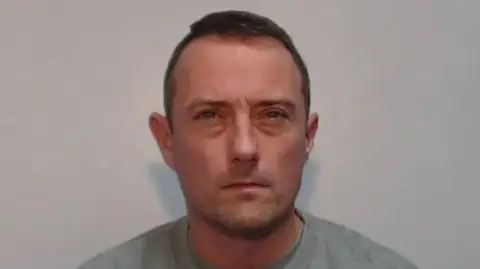 Police handout Police custody image of Jamie Cassidy with brown hair wearing a grey t-shirt.