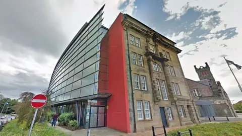 Google a council headquarters with stone on one side and glass panel under an inauspicious sky on the other side