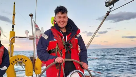 Norfolk and Suffolk NHS Foundation Trust Team member Ethan at the helm of the yacht