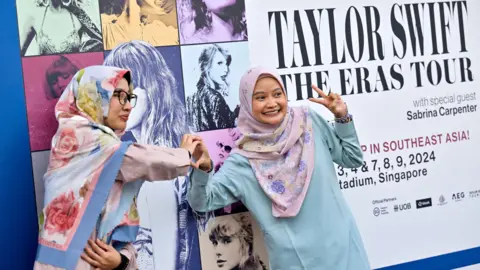 Reuters Taylor Swift's fans, or Swifties, pose for a picture at the National Stadium during Swift's Eras Tour concert in Singapore