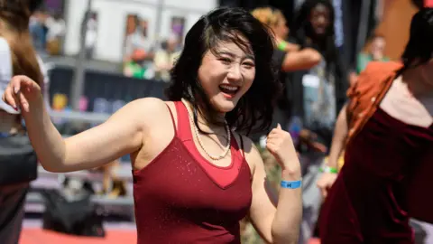 A woman dancing in a red top