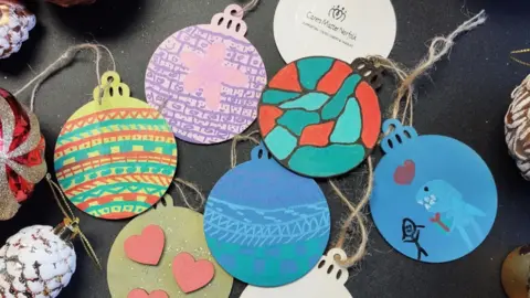 Voluntary Norfolk A selection of colourful decorated baubles by young carers from Voluntary Norfolk.