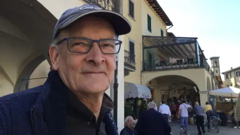 Lucille Strachan Dave is pictured on one of his holidays since retiring. He's in a busy market place.