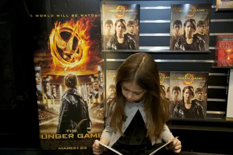 Getty Images Girl reading Hunger Games book