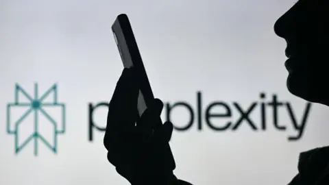 A silhoutted figure is shown holding their smartphone and looking at it in front of a white background displaying the Perplexity logo.