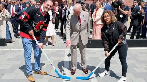 Getty Images King Charles III drops the puck to launch the hockey match at a community event in Lansdowne Park during an official visit to Canada on May 26, 2025 in Ottawa, Ontario.