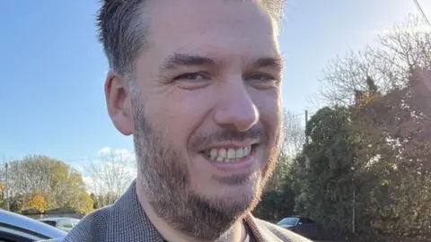 Man with beard smiling at camera