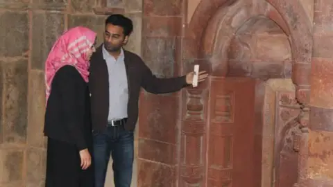 Suri married a Palestinian whom he had met on a visit to Gaza with a humanitarian convoy. He is seen with his wife. He is wearing a shirt and a jacket over jeans, while she is wearing a black abaya with a pink scarf.