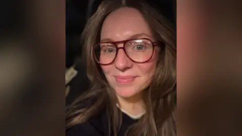 Claire Kieran Claire Kieran. She has long dark brown hair, wearing glasses and a black jumper.