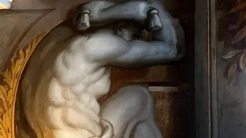 Emma Baugh/BBC Part of a painting shows a naked man with something on his head