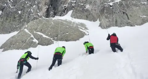 Soccorso Alpino e Speleologico Trentino Rescue teams search the mountainous range for the two missing hikers.