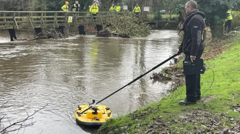 A swollen river with a small yellow boat in the water