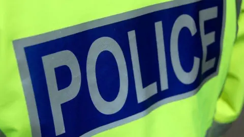 BBC close-up of a police officer's jacket and the word "police".