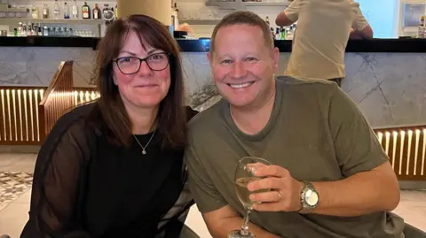 Jason Walker Jason and his wife sit in a restaurant smiling.