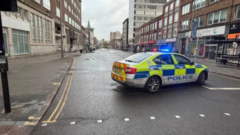 Police car in front of a cordon