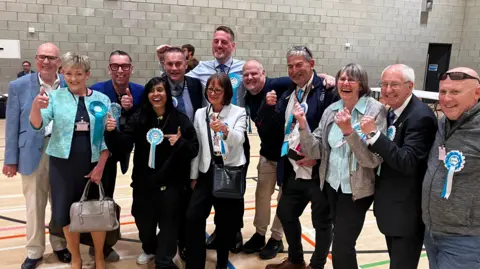 A group of Reform UK candidates celebrating.