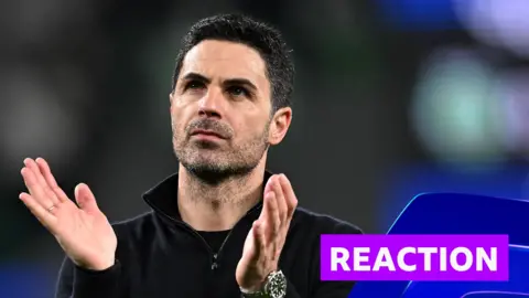 Mikel Arteta looks towards crowd and does a clapping hand motion 