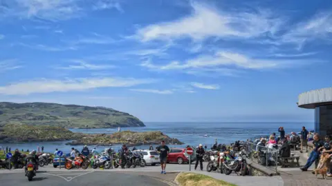 MANX SCENES Scores of motorbikes and people outside the cafe at the Sound, which overlooks the Calf of Man and Chickens Rock.
