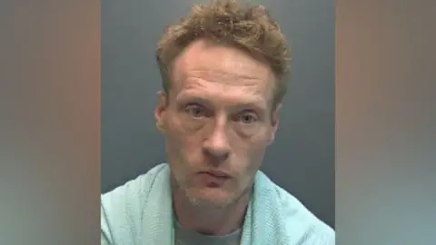 Hertfordshire Constabulary A custody photo shows a man with short hair