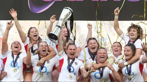 England captain Meg Jones lifts the Women's Six Nations trophy surrounded by her team-mates