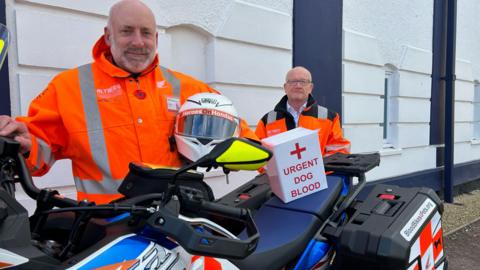 Tom Watkins and Richard Eldridge next to a motorbike that will deliver pet blood.