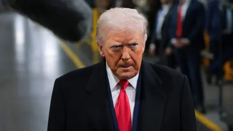 US President Donald Trump walks around a Ford factory