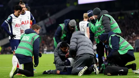 Rodrigo Bentancur receives treatment on the pitch in Tottenham's game against Liverpool