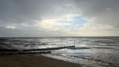 Thorpe Bay beach is pictured during a cloudy day. The tide is out and the beach's sea groynes can be seen clearly.