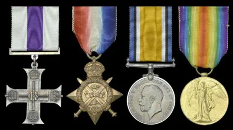 Noonans Four military medals on a black background, with colourful ribbons. The first is a silver cross with white and purple striped ribbon.