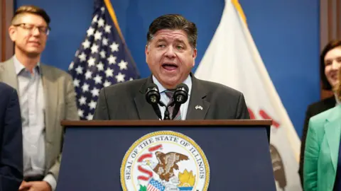 AFP via Getty Images Illinois Governor JB Pritzker speaks during a news conference