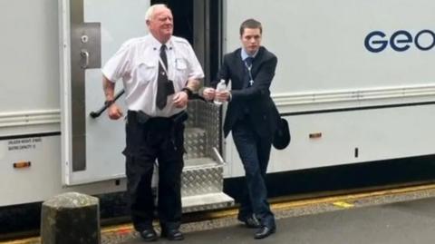Liam Stimpson being led from custody van