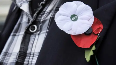 Getty Images A white and red poppy worn alongside each other