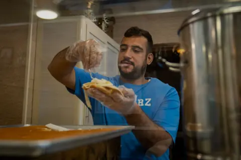 Joel Gunter/BBC Yusuf Habbal in his shop in Beirut. 