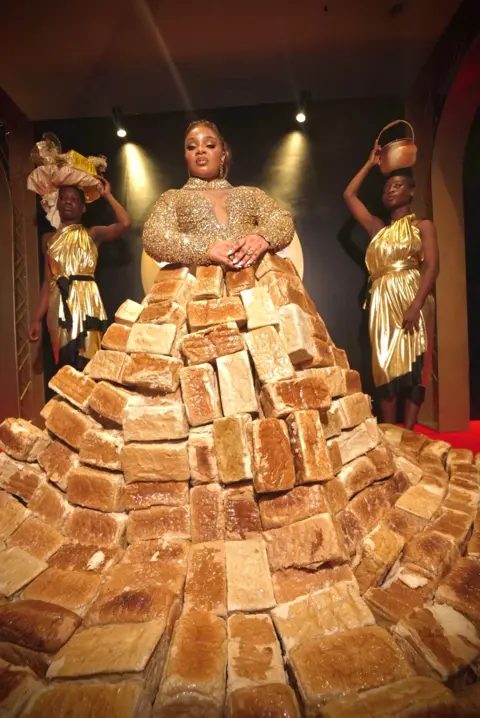BBC/GIFT UFUOMA Reality TV star Queen Mercy Atang  is seen with her dress made from loaves of bread