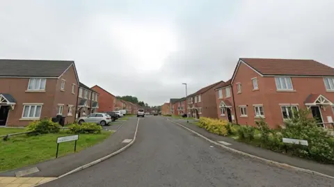 Google A street of modern two-storey red brick houses.