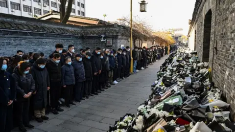 Getty Images Mourners obvservce 3 minutes of respect outside Jiang's former home in Yangzhou