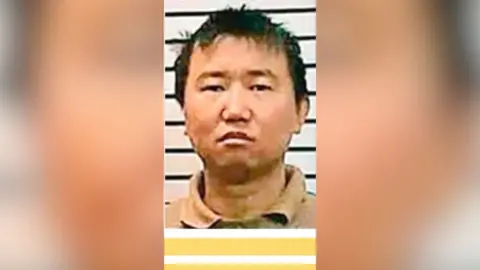 A mugshot of man with short dark hair