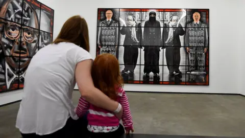 Reuters A woman and her child look at an artwork at the opening of the new Gilbert and George exhibition at the Metropolitan Arts Centre (MAC) in Belfast in January 2018