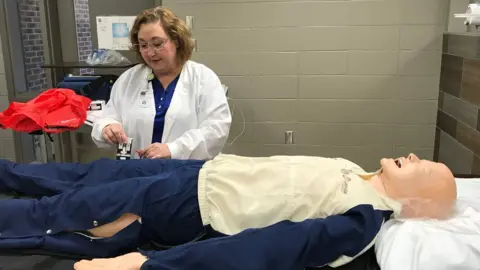 BBC School nurse Treasa Daly demonstrates how an opioid antidote is used, in Shelby County, Alabama