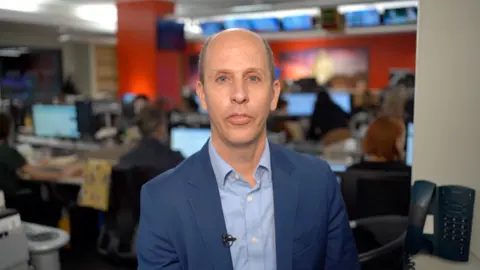 Anthony Zurcher wearing a suit   successful  a newsroom