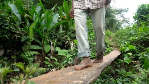 A man walks barefoot across a board