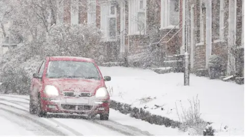 PA Media A car driving through a snow flurry in Lenham, Kent