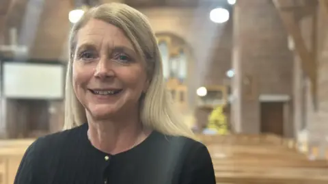 Woman in black top with blond hair