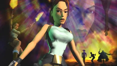 An image showing an early depiction of Lara Croft from the Tomb Raider video games. She is standing in her famous outfit consisting of a green T-shirt and beige trousers. behind her to the left is another picture of her firing two guns into the air. An explosion is taking place to her right with three silhouettes in front of the blast.